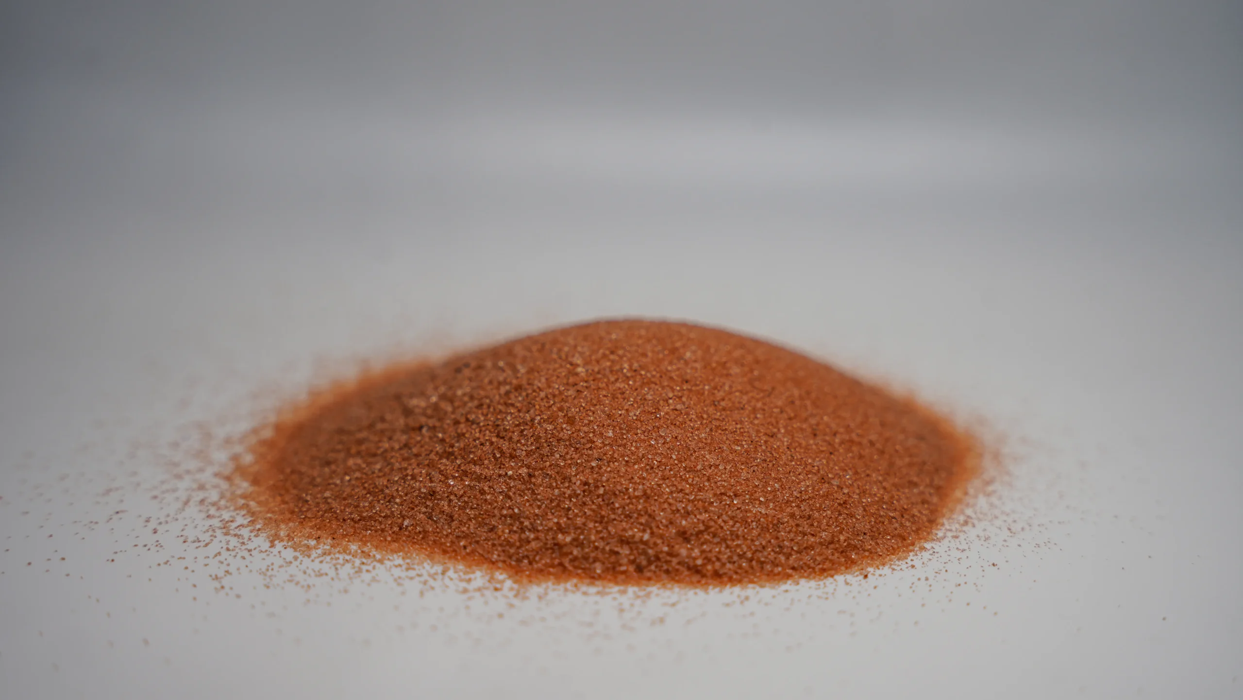 A small pile of reddish-brown granular sand