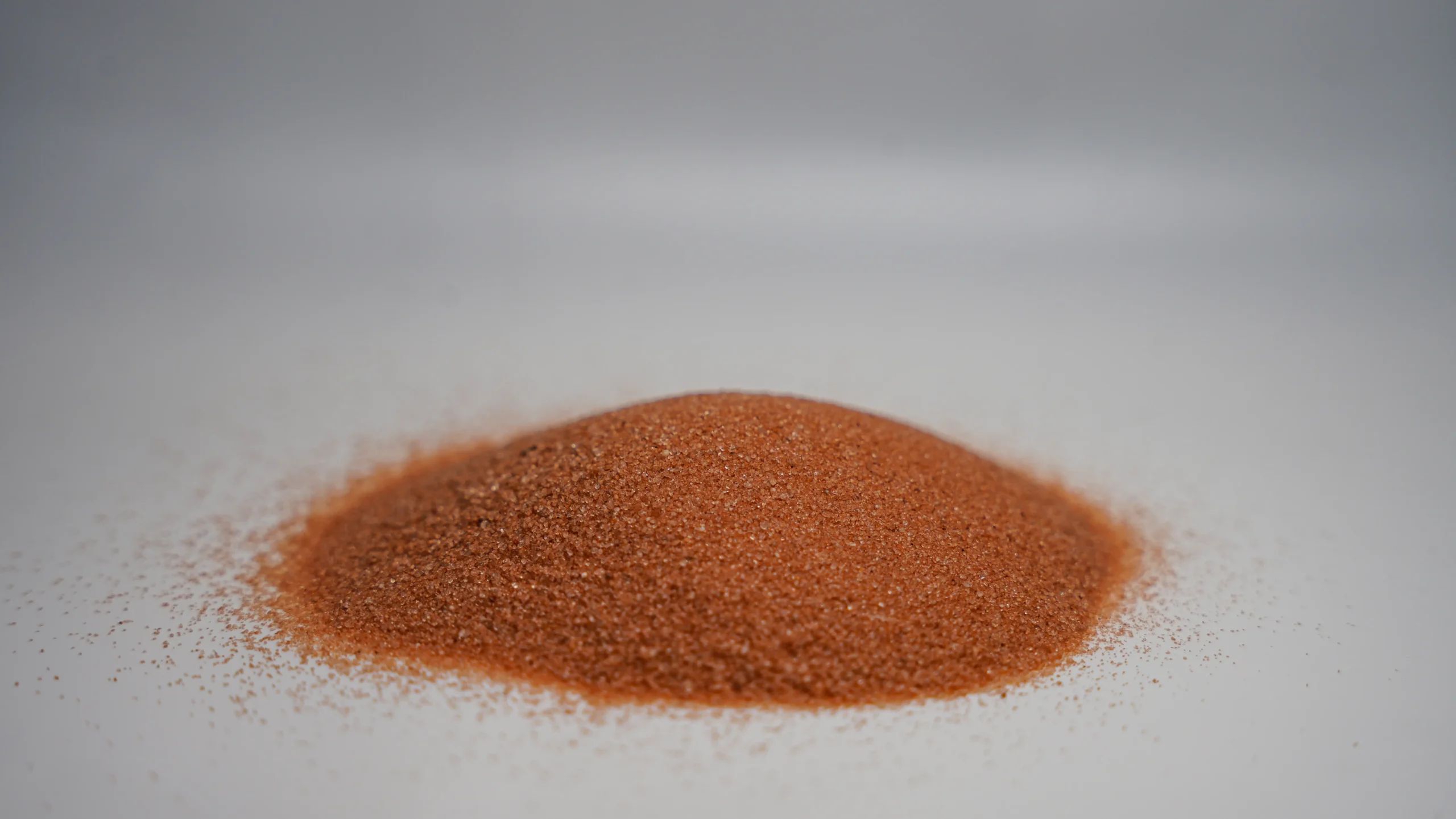 A small pile of reddish-brown granular sand